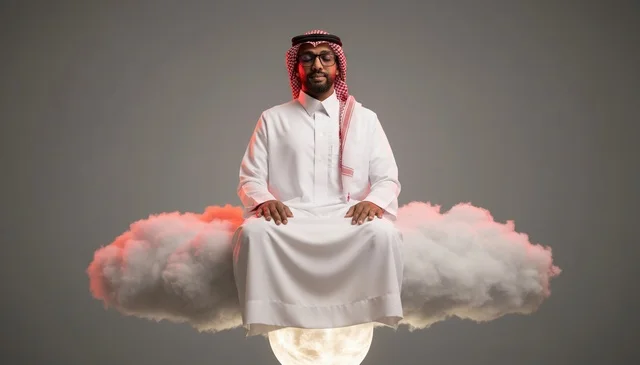 رجل سعودي يتأمل فوق سحابة طافية في الاستوديو