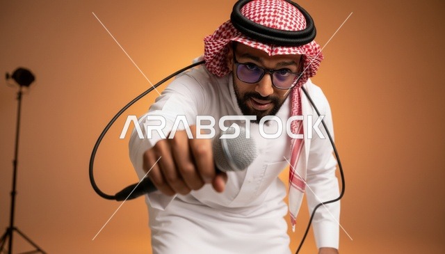 رجل سعودي يحمل ميكروفون في استوديو تصوير