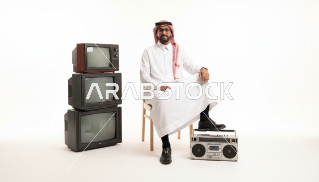 رجل سعودي مع أجهزة تلفاز قديمة ومسجل كلاسيكي