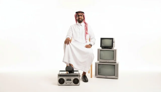 Saudi Man with Vintage Radio and Old Televisions