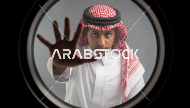 رجل سعودي يشير بالتوقف من فتحة الباب