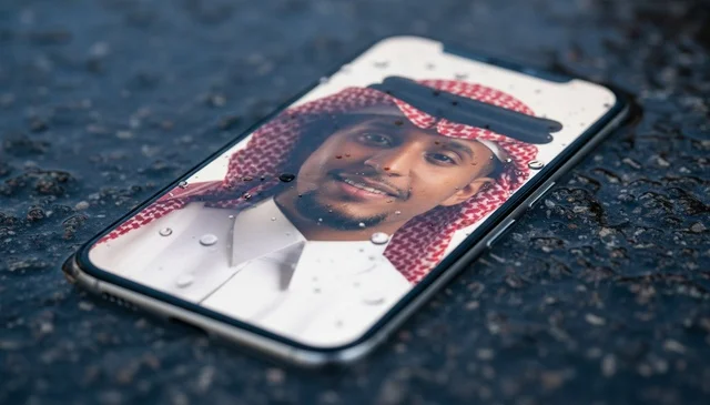 Saudi Man Portrait on Smartphone Screen on Wet Pavement