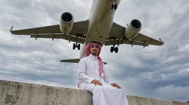 رجل سعودي بالثوب التقليدي تحت طائرة تهبط