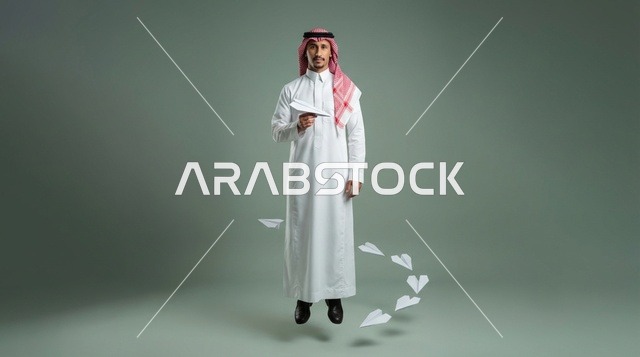 رجل سعودي بالثوب يحمل طائرة ورقية في الاستوديو