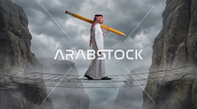 رجل سعودي يحمل قلم رصاص ضخم على جسر بين الجبال