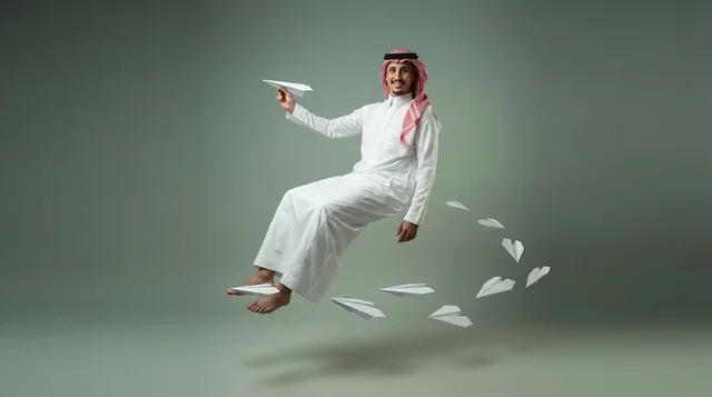 Saudi Man Floating with Paper Airplanes in Studio