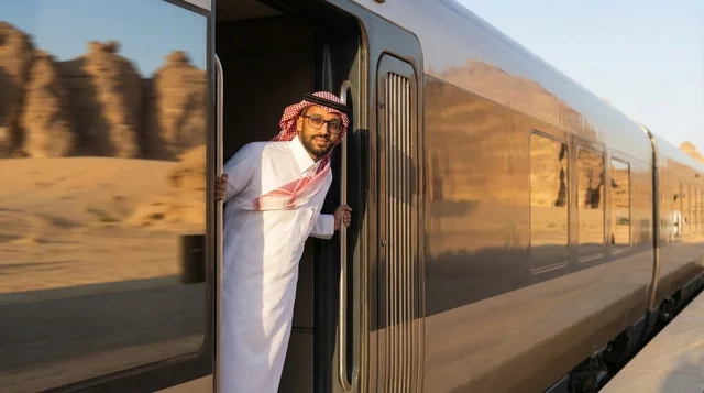 Saudi Man in Traditional Dress on Modern Train in Desert
