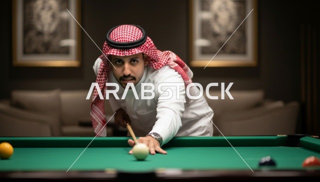 رجل سعودي بالزي التقليدي يلعب البلياردو بتركيز