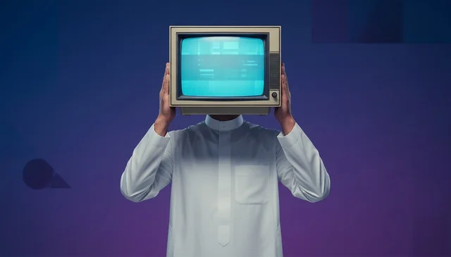 رجل سعودي بالثوب التقليدي يضع جهاز تلفاز قديم مكان الرأس