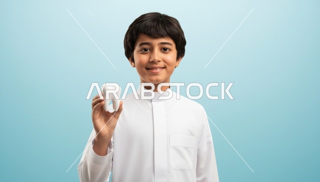ولد سعودي بالثوب يحمل مجسم سن طبي