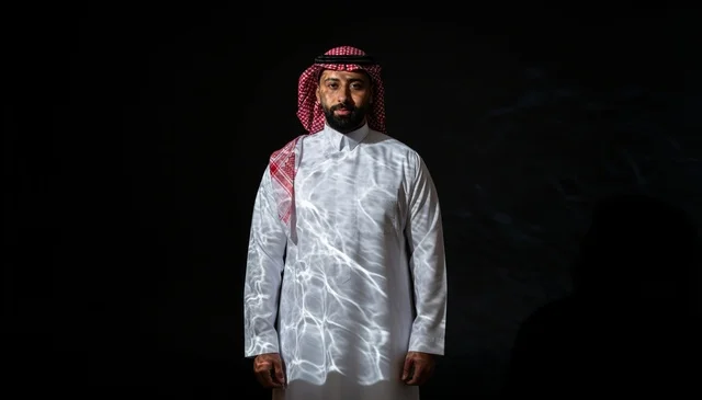 رجل سعودي بالزي التقليدي بإضاءة درامية خافتة