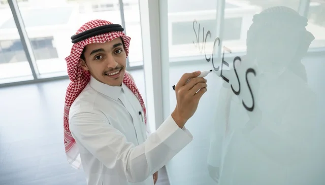 Saudi Businessman Writing Success on Glass Board