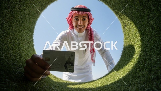 رجل سعودي يحمل بطاقة بنكية عبر فتحة دائرية