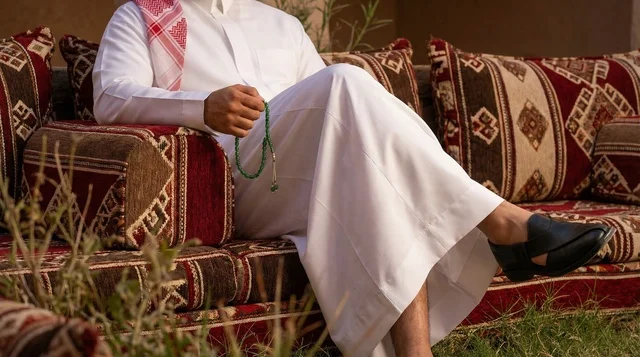 رجل سعودي بالثوب التقليدي والمسبحة في جلسة عربية