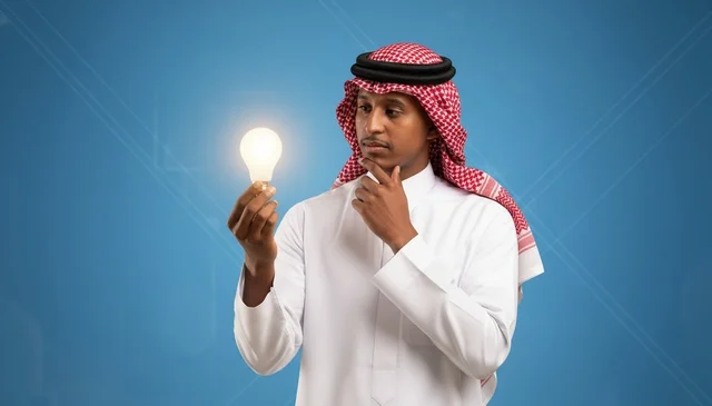 A Saudi man holding a lit lamp to express innovation.