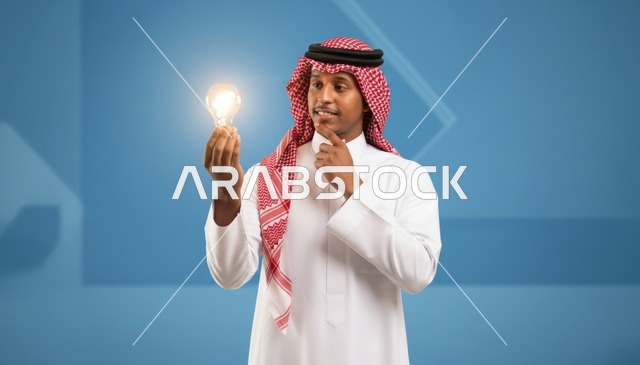 رجل سعودي يمسك بمصباح مضيء لمفهوم الابتكار والإبداع