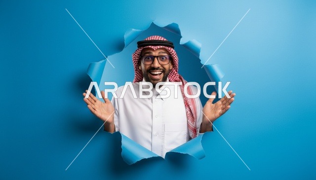 رجل سعودي بملابس تقليدية ينظر بحماس من خلفية زرقاء