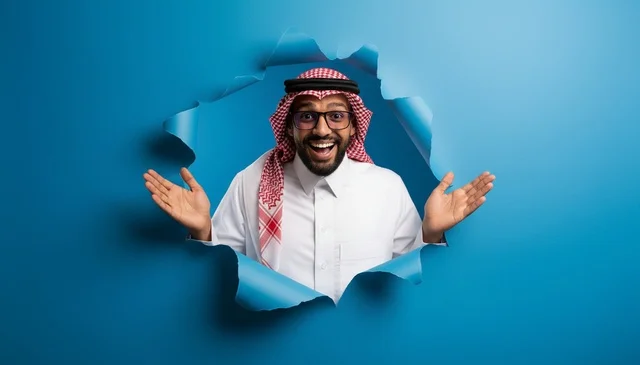 Excited Saudi Man Emerging Through Torn Blue Paper