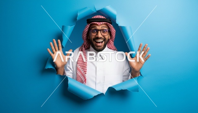 رجل سعودي متحمس خلف خلفية ورقية زرقاء ممزقة