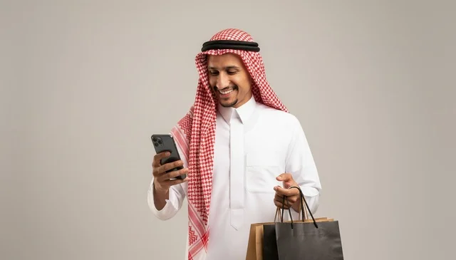 Saudi Man with Shopping Bags Using Smartphone