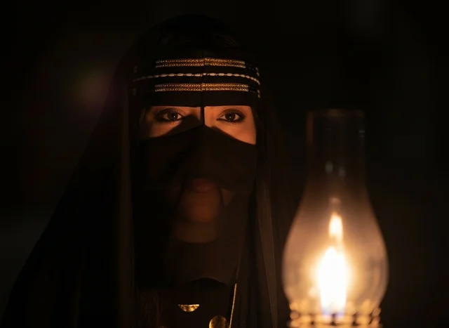 امرأة سعودية بالنقاب التقليدي مع فانوس قديم