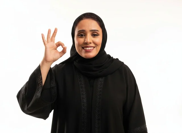 امرأة سعودية بالعباءة السوداء تشير بعلامة الموافقة