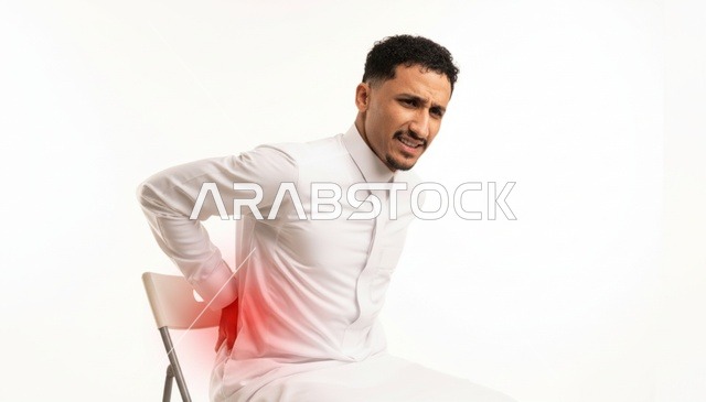 رجل سعودي بالثوب يعاني من آلام الظهر