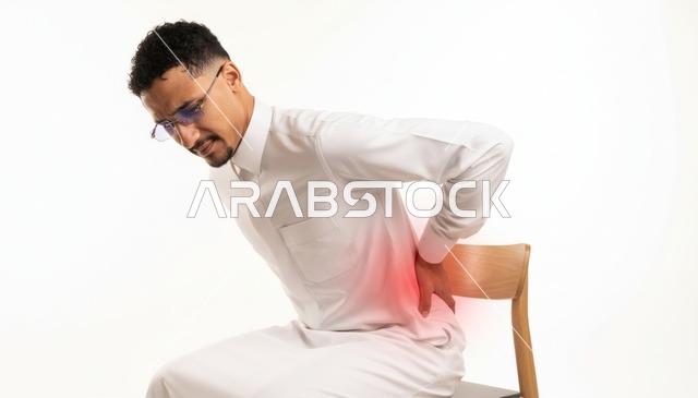 رجل سعودي يرتدي الثوب يعاني من ألم الظهر
