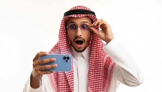 رجل سعودي مصدوم يحمل هاتف ذكي خلفية بيضاء رجل سعودي مصدوم يحمل هاتف ذكي خلفية بيضاء