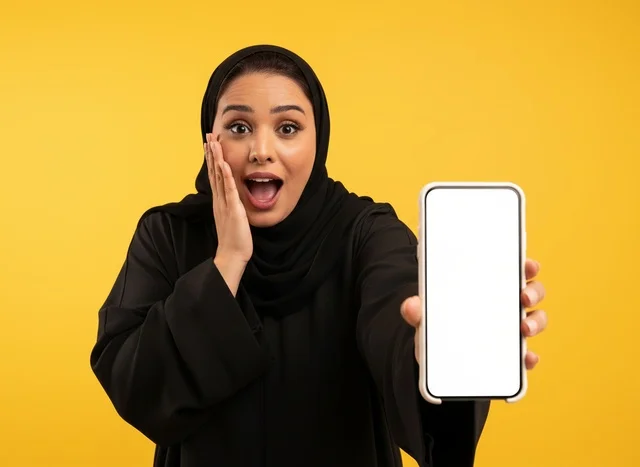 Surprised Emirati Woman Holding Smartphone Blank Screen
