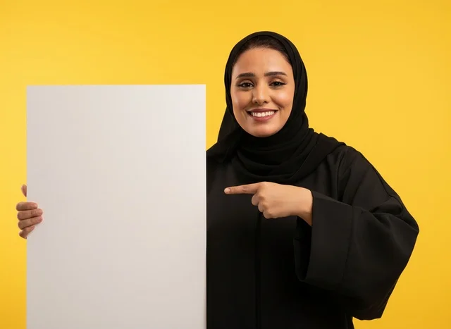 امرأة إماراتية تشير إلى لوحة بيضاء فارغة خلفية صفراء