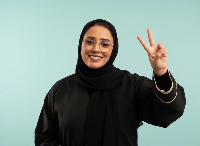 امرأة سعودية بالعباءة تقوم بعلامة النصر امرأة سعودية بالعباءة تقوم بعلامة النصر
