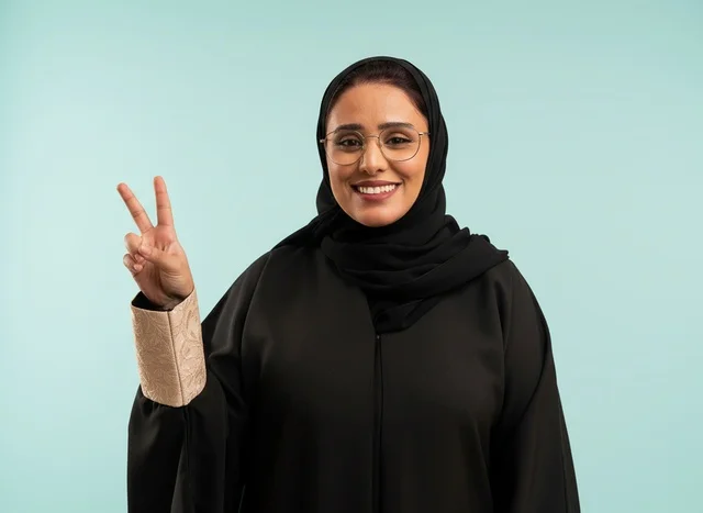 Saudi Woman in Abaya Making Peace Sign Studio Portrait