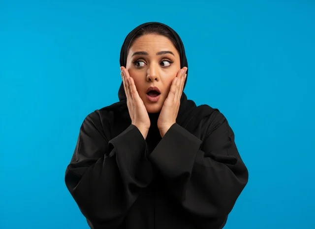 Shocked Saudi Woman in Abaya on Blue Background