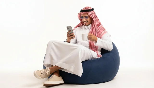 مواطن سعودي يستخدم الهاتف الذكي على مقعد محشو