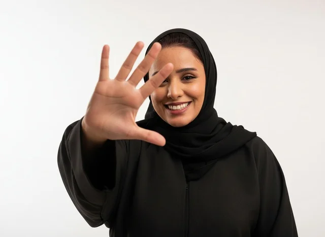 امرأة سعودية بالعباءة تشير برقم خمسة