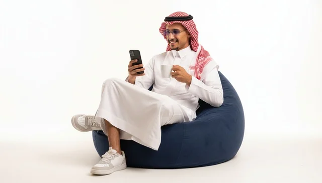 رجل سعودي يجلس على مقعد استرخاء مع هاتف ذكي