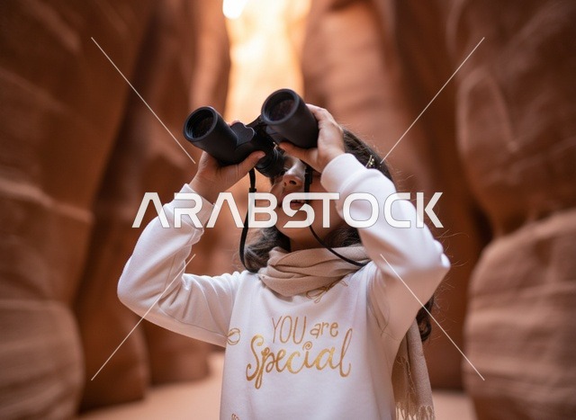 Arab Girl Using Binoculars in Sandstone Canyon