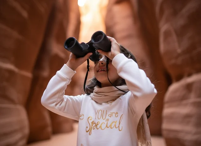 Arab Girl Using Binoculars in Sandstone Canyon