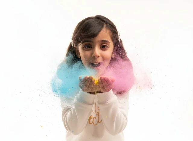 Young Saudi Girl Blowing Colored Powder on White Background