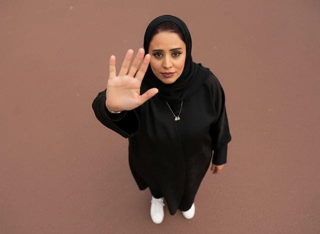 Emirati Woman in Black Abaya Making Stop Gesture