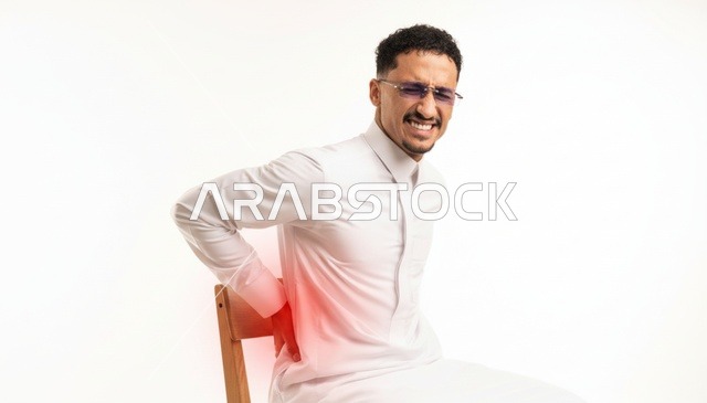 رجل سعودي بالثوب الأبيض يعاني من آلام أسفل الظهر