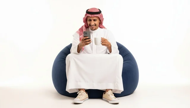 Saudi Man with Smartphone and Mug on Beanbag