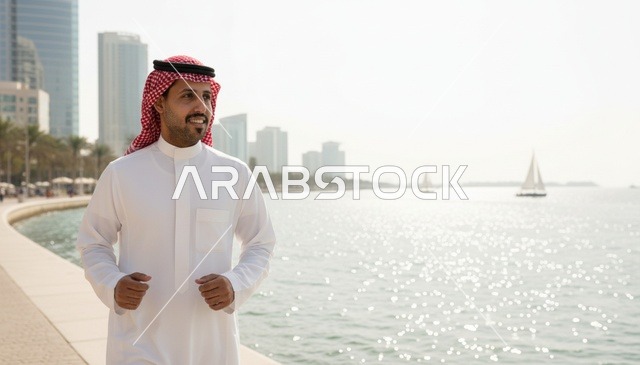 رجل سعودي يمشي على ممشى الواجهة البحرية للمدينة
