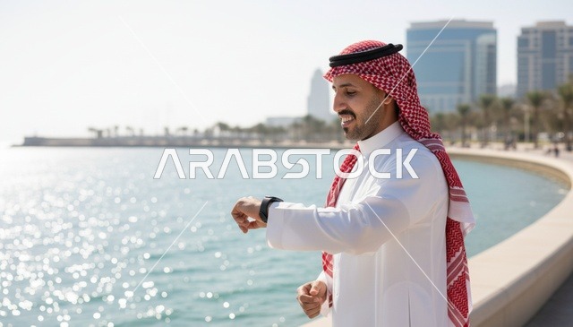 رجل سعودي مع ساعة ذكية على الكورنيش البحري