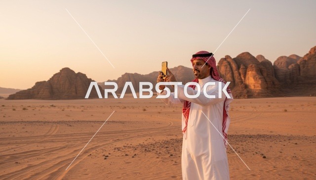 رجل سعودي يصور في الصحراء وقت الغروب