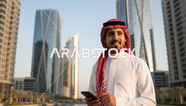 رجل سعودي يستخدم الهاتف الذكي في مدينة حديثة