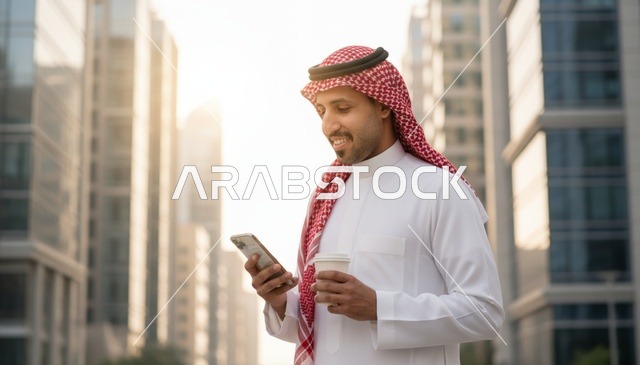 رجل سعودي يستخدم الهاتف الذكي في مدينة حديثة