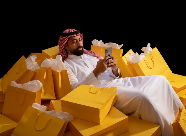 Saudi Man with Yellow Shopping Bags using Smartphone