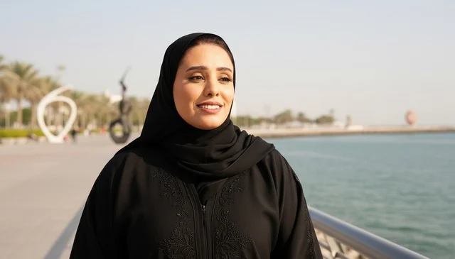 امرأة إماراتية بالعباءة السوداء على بحر أبو ظبي